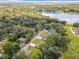Aerial view of homes surrounded by lush trees and a tranquil lake in the distance at 501 Mulberry St, Fruitland Park, FL 34731