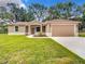 Charming single-story home with beautiful landscaping and a two-car garage at 501 Mulberry St, Fruitland Park, FL 34731