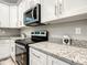 The kitchen features stainless steel appliances, elegant granite countertops, and sleek modern cabinets at 501 Mulberry St, Fruitland Park, FL 34731