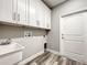 A functional laundry area equipped with lots of storage space and wood-style vinyl floors at 501 Mulberry St, Fruitland Park, FL 34731