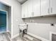 A functional laundry area equipped with lots of storage space and wood-style vinyl floors at 501 Mulberry St, Fruitland Park, FL 34731