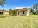 Home with a backyard, covered patio, green lawn, and mature trees in a residential neighborhood at 509 Mulberry St, Fruitland Park, FL 34731