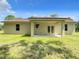 Back of the home showing the yard, covered patio, and matching french doors at 509 Mulberry St, Fruitland Park, FL 34731