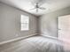 A bedroom that features neutral walls, a ceiling fan, and a large window at 509 Mulberry St, Fruitland Park, FL 34731
