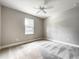 Bright bedroom featuring a ceiling fan, plush carpet, and a window with natural light at 509 Mulberry St, Fruitland Park, FL 34731