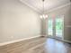 Bright dining room with wood-look floors, modern chandelier, and french doors to the yard at 509 Mulberry St, Fruitland Park, FL 34731