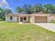 Charming single-story home featuring a manicured lawn, two-car garage, and fresh landscaping at 509 Mulberry St, Fruitland Park, FL 34731