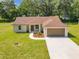 Charming single-story home featuring a two-car garage, walkway, landscaping, and green lawn at 509 Mulberry St, Fruitland Park, FL 34731