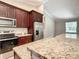Modern kitchen with dark cabinets, granite countertops, and stainless steel appliances at 509 Mulberry St, Fruitland Park, FL 34731