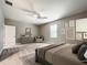 Spacious main bedroom featuring neutral walls, ceiling fan, a sitting area, and an ensuite bathroom at 509 Mulberry St, Fruitland Park, FL 34731