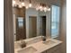 Bathroom featuring double sinks with quartz countertop, stylish lighting and a glass shower at 618 Duke Dr, Haines City, FL 33844