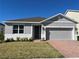 Charming single-story home features a well-maintained lawn, a brick driveway, and a neutral color scheme at 618 Duke Dr, Haines City, FL 33844