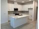 Bright kitchen with white cabinetry, stainless steel appliances, island with quartz countertop, and subway tile backsplash at 618 Duke Dr, Haines City, FL 33844