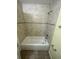 Tiled tub and shower combo in bathroom, featuring neutral finishes and hardware at 6427 Breezewood St, Orlando, FL 32818