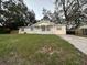 Traditional-style home featuring a green lawn and a driveway in a quiet neighborhood at 6427 Breezewood St, Orlando, FL 32818
