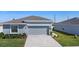 Charming home with a gray exterior, well-manicured landscaping, and a two-car garage at 660 Silver Palm Dr, Haines City, FL 33844
