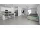 Open-concept kitchen and living area with stainless steel appliances and gray tile flooring at 660 Silver Palm Dr, Haines City, FL 33844