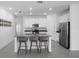 Bright kitchen features white cabinets, a kitchen island with barstool seating, and stainless steel appliances at 660 Silver Palm Dr, Haines City, FL 33844