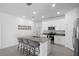 White kitchen with stainless steel appliances and an island with bar seating is bright and open at 660 Silver Palm Dr, Haines City, FL 33844