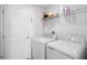 Well-lit laundry room includes a side-by-side washer and dryer set and storage shelves at 660 Silver Palm Dr, Haines City, FL 33844