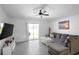 Comfortable living room with a large sectional sofa, tile floors, and a sliding glass door to the backyard at 660 Silver Palm Dr, Haines City, FL 33844