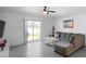 Bright living room with a sliding glass door leading to the backyard, tile floors, and a gray sectional sofa at 660 Silver Palm Dr, Haines City, FL 33844