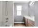 A clean bathroom with white tile, wood-look floors, and a wooden vanity at 745 Riggs Cir, Davenport, FL 33897
