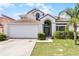 Charming two-story home featuring a manicured lawn, attached two-car garage, and inviting front entrance at 745 Riggs Cir, Davenport, FL 33897
