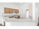 Well-lit kitchen with white countertops, wood cabinets and tile floor at 745 Riggs Cir, Davenport, FL 33897