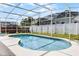 A screened-in pool is surrounded by concrete and a white fence at 745 Riggs Cir, Davenport, FL 33897