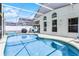 A sunny pool with an enclosed screen is surrounded by a deck and white fence at 745 Riggs Cir, Davenport, FL 33897