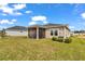 Home's screened-in back porch and neat lawn, set against a backdrop of lush greenery and blue skies at 7536 Sw 77Th Ave, Ocala, FL 34481