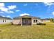 Charming home featuring a screened-in porch overlooking a well-maintained, expansive backyard under a bright blue sky at 7536 Sw 77Th Ave, Ocala, FL 34481