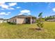 Backyard view of a home with a screened-in patio, green lawn, and minimal landscaping at 7536 Sw 77Th Ave, Ocala, FL 34481