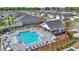 Aerial view of community pool with chairs and tables, white pool house, landscaping, and neighborhood homes at 7536 Sw 77Th Ave, Ocala, FL 34481