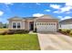 Attractive home exterior with a well-maintained lawn, a two-car garage, and landscaped garden beds at 7536 Sw 77Th Ave, Ocala, FL 34481