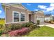Inviting home exterior showcasing stone accents, lush flower beds, and a well-maintained lawn at 7536 Sw 77Th Ave, Ocala, FL 34481