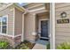 Home's exterior showing the front door, stone accents, tidy landscaping, and visible house numbers at 7536 Sw 77Th Ave, Ocala, FL 34481