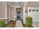 Front entrance displaying stone accents, a dark-colored door, and a wreath with tidy landscaping at 7536 Sw 77Th Ave, Ocala, FL 34481