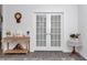 Hallway view to french doors, wooden table, and gray wood-look floors at 7536 Sw 77Th Ave, Ocala, FL 34481