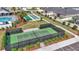Aerial view of community tennis courts with green surface surrounded by black fence and mature landscaping at 7536 Sw 77Th Ave, Ocala, FL 34481