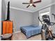 Cozy bedroom featuring a bed, ceiling fan, wall mounted TV and exercise machine at 9210 Sw 60Th Court Rd, Ocala, FL 34476