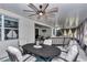 Relaxing screened-in patio featuring a ceiling fan, comfortable seating, and an elegant dining area at 9210 Sw 60Th Court Rd, Ocala, FL 34476