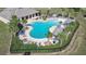 Aerial view of large community pool with crystal clear water, lounge seating, and palm trees all around at 9210 Sw 60Th Court Rd, Ocala, FL 34476