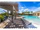 Relaxing poolside pergola featuring comfortable lounge chairs and a beautiful view of the stunning community pool at 9210 Sw 60Th Court Rd, Ocala, FL 34476