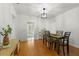 Bright dining room with hardwood floors, modern light fixture, table with four chairs, and open access to other rooms at 926 Mayfair Cir, Orlando, FL 32803