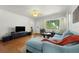 Cozy living room with hardwood floors, large windows, a light blue sofa, and modern media console at 926 Mayfair Cir, Orlando, FL 32803