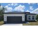 Charming single-story home featuring a gray garage door, stone accents, and a well-maintained lawn at 1408 Sarasota Way, Kissimmee, FL 34759