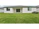 Wide shot of a lush backyard with newly installed sod, featuring a covered patio and slider access at 2352 Citrus Bloom Dr, Bartow, FL 33830