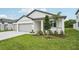 Charming home with a two-car garage, green lawn, manicured landscaping, and a walkway to the front door at 2352 Citrus Bloom Dr, Bartow, FL 33830